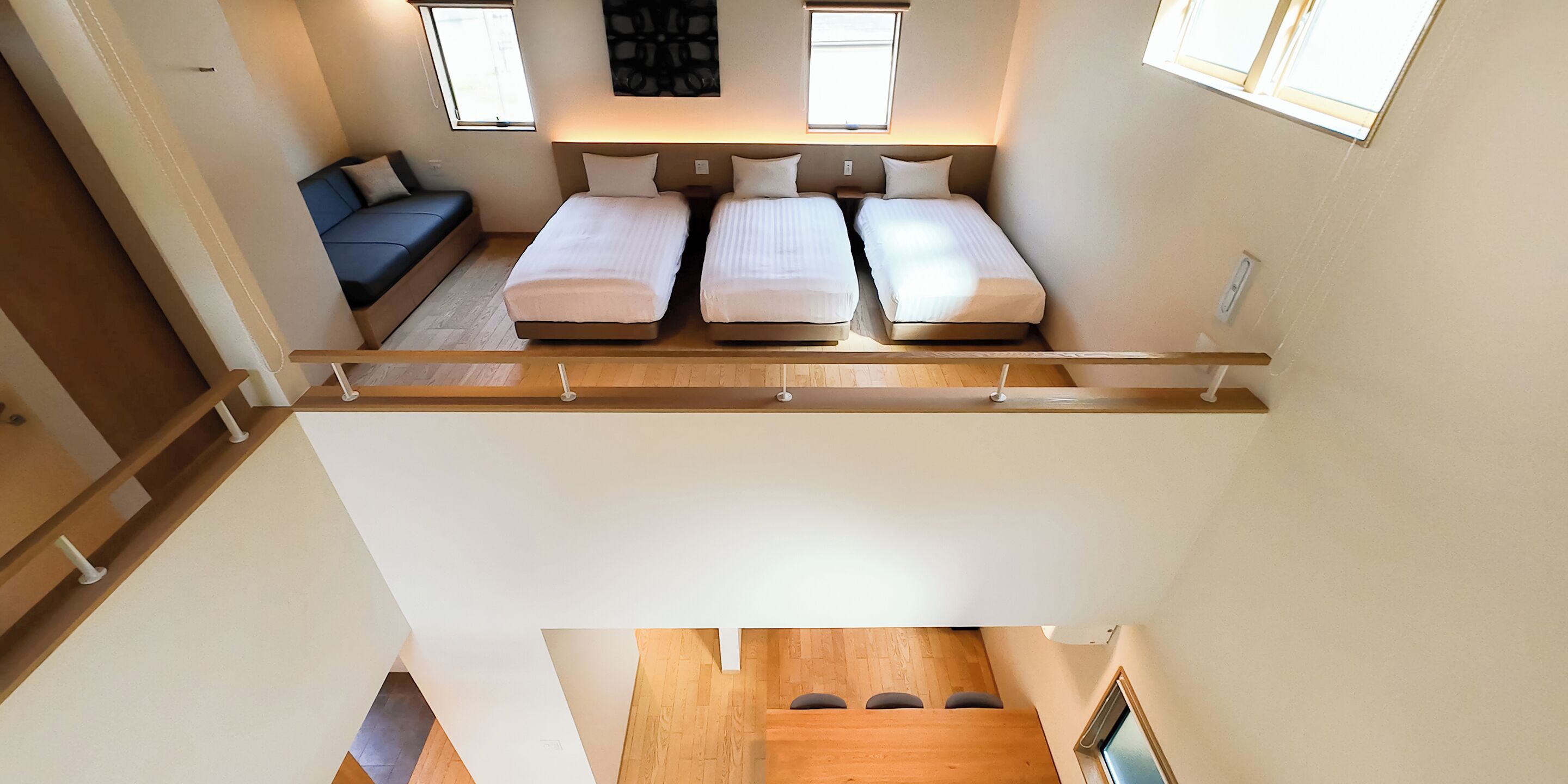 A compact room with two single beds, a sofa, and a small table.