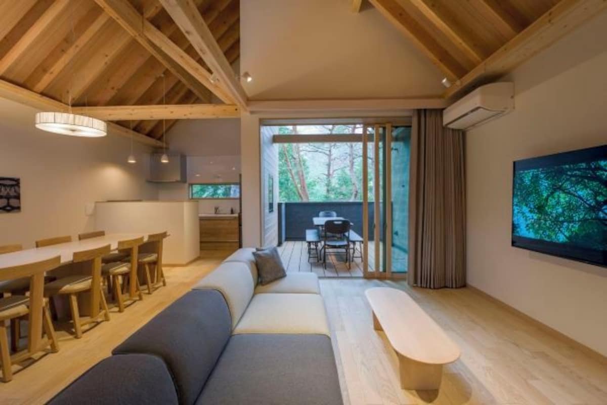 A modern interior with a dining area, sofa, and a television.