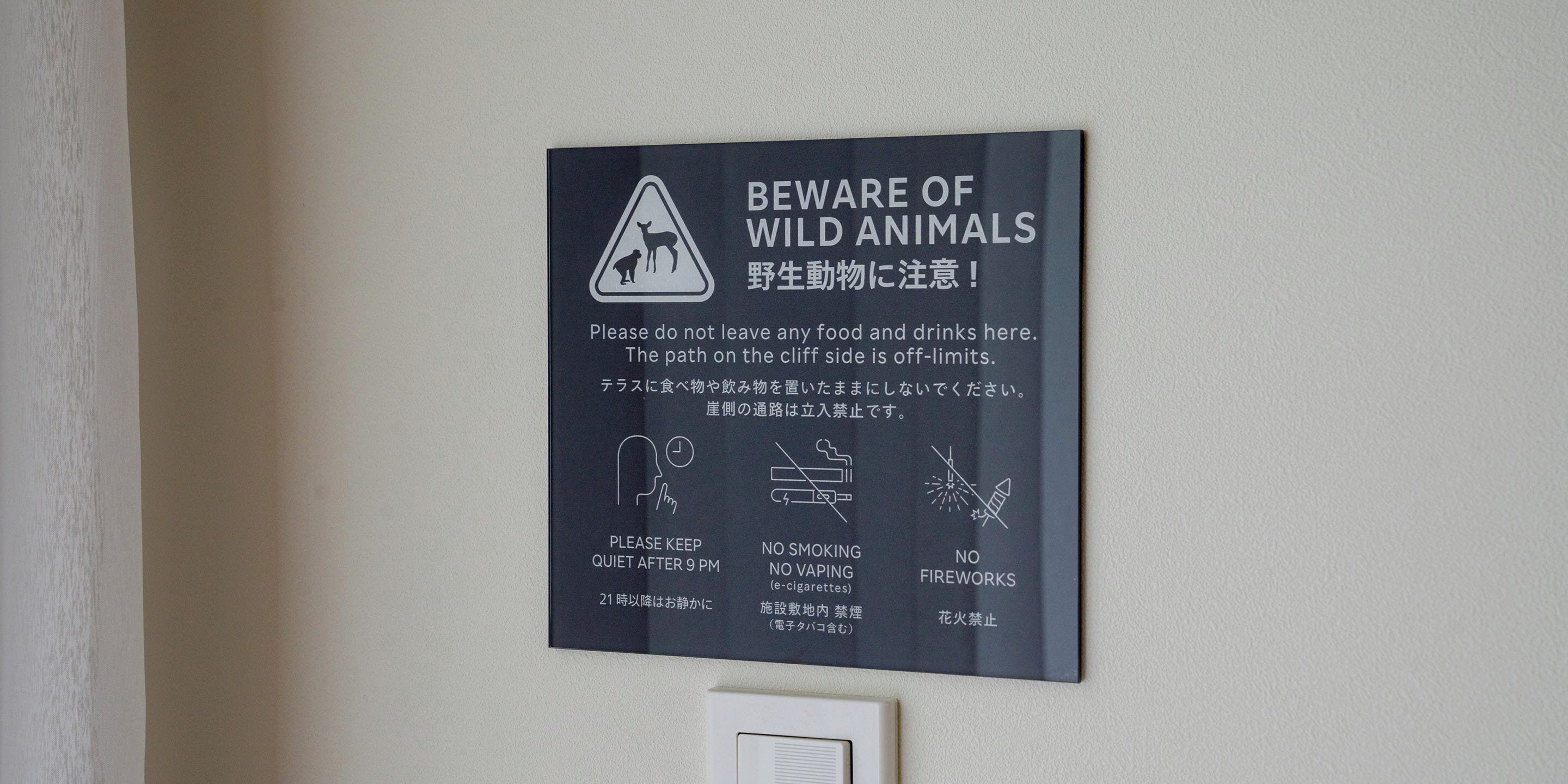 A sign with warnings about wild animals, quiet hours, no smoking, no vaping, and no fireworks.