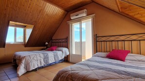 Camera da letto con due letti, soffitto in legno e una finestra.
