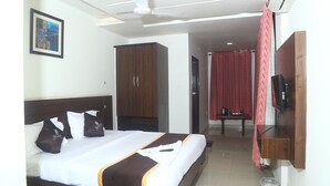 A hotel room with a bed, a wardrobe, a TV, and a bathroom visible in the background. - Park Niveda (Hyderabad)