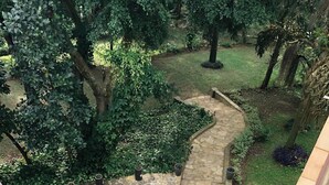 A stone staircase with metal railings leading to a garden area with trees and a stone wall. - The address resort (Bugala Island)