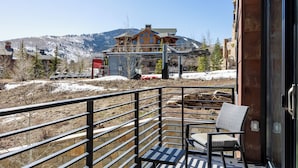 A balcony with a view of a mountain and a large building.
