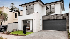 A modern two-story house with a garage, a well-maintained lawn, and a paved driveway. - Lamington's Landing near Seacliff Beach (Seacliff Park)