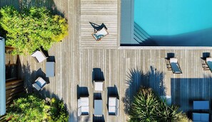 An aerial view of a wooden deck with lounge chairs and a pool. - Villa à la Pointe du Cap Ferret (Lège-Cap-Ferret)