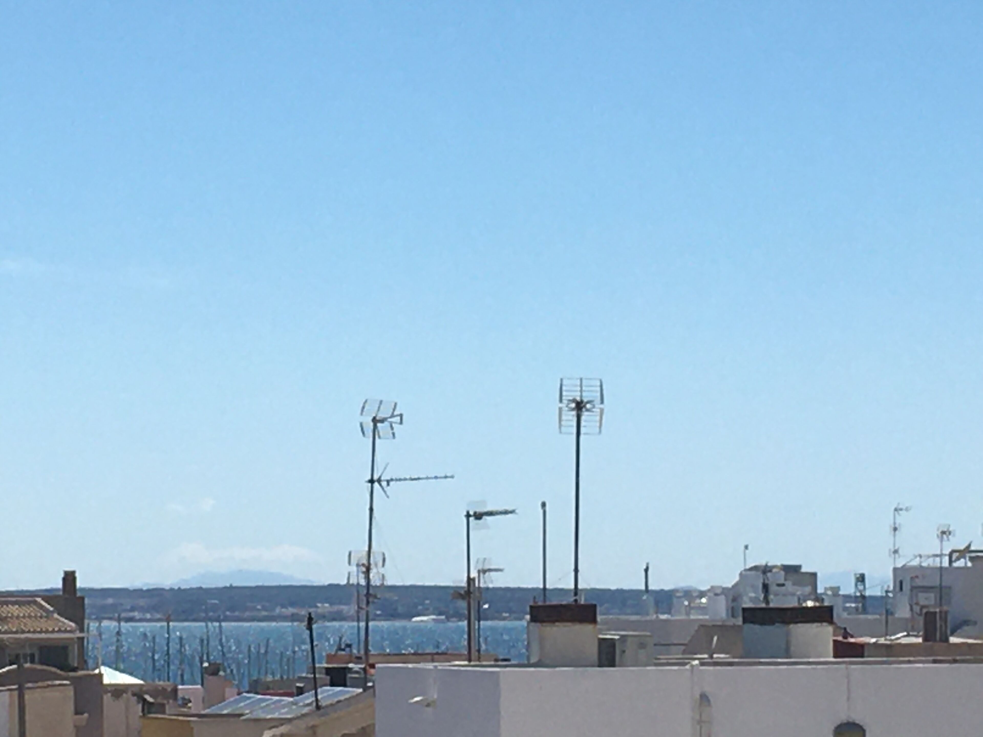 Un toit équipé de plusieurs antennes et offrant une vue dégagée sur la mer.