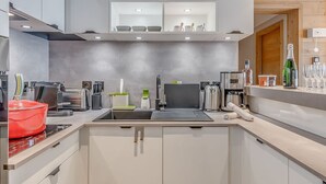 Una cocina moderna con pileta integrada, cafetera y enfriador de vinos.