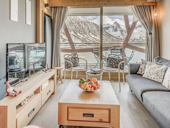Relax in this inviting living room with a mountain view, featuring a sofa, coffee table, and TV.