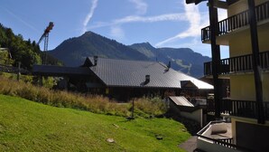 A building with a sloped roof and a balcony overlooking a mountainous landscape. - Functional apartment in Châtel center, near ski lifts (Châtel)