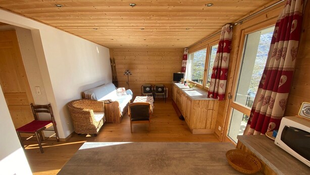 A wooden interior with a sofa, chairs, a table, and a kitchen area with a microwave. - Functional apartment in Châtel center, near ski lifts (Châtel)