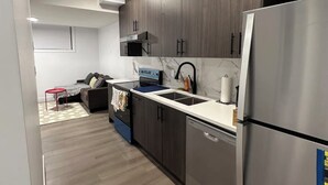 Una cocina moderna con armarios de madera oscura, un refrigerador de acero inoxidable y un horno empotrado.