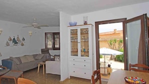 A living room with a sofa, chairs, a dining table, and a cabinet.