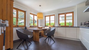 Una cocina moderna con armarios de madera, una isla central y ventanas grandes.