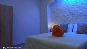 A bedroom with a bed, pillows, and a decorative orange object.