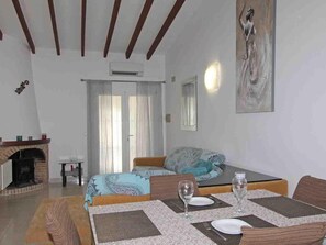 Una stanza con un letto, un tavolo da pranzo per due persone, un camino e un quadro appeso al muro.