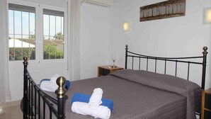 A bedroom with a bed, a nightstand, a window, and a wall-mounted artwork. - Cozy Holiday Home in Moraira with Communal Pool, Near Golf & Beach, Perfect for Families (Moraira)