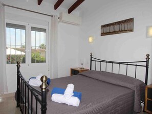 Una camera da letto con un letto, un comodino, una finestra e un'opera d'arte appesa al muro.