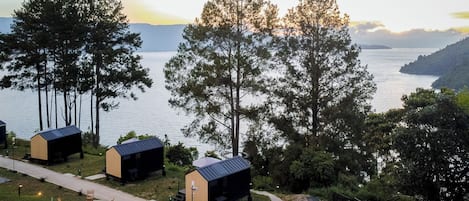 A lakeside property with several cabins, a walking path, and a view of the lake and mountains.