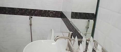 A bathroom with a white sink, a mirror, and a shower area.
