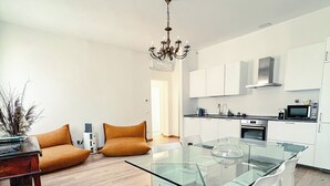 A modern kitchen with white cabinets, a built-in oven, and a microwave.
