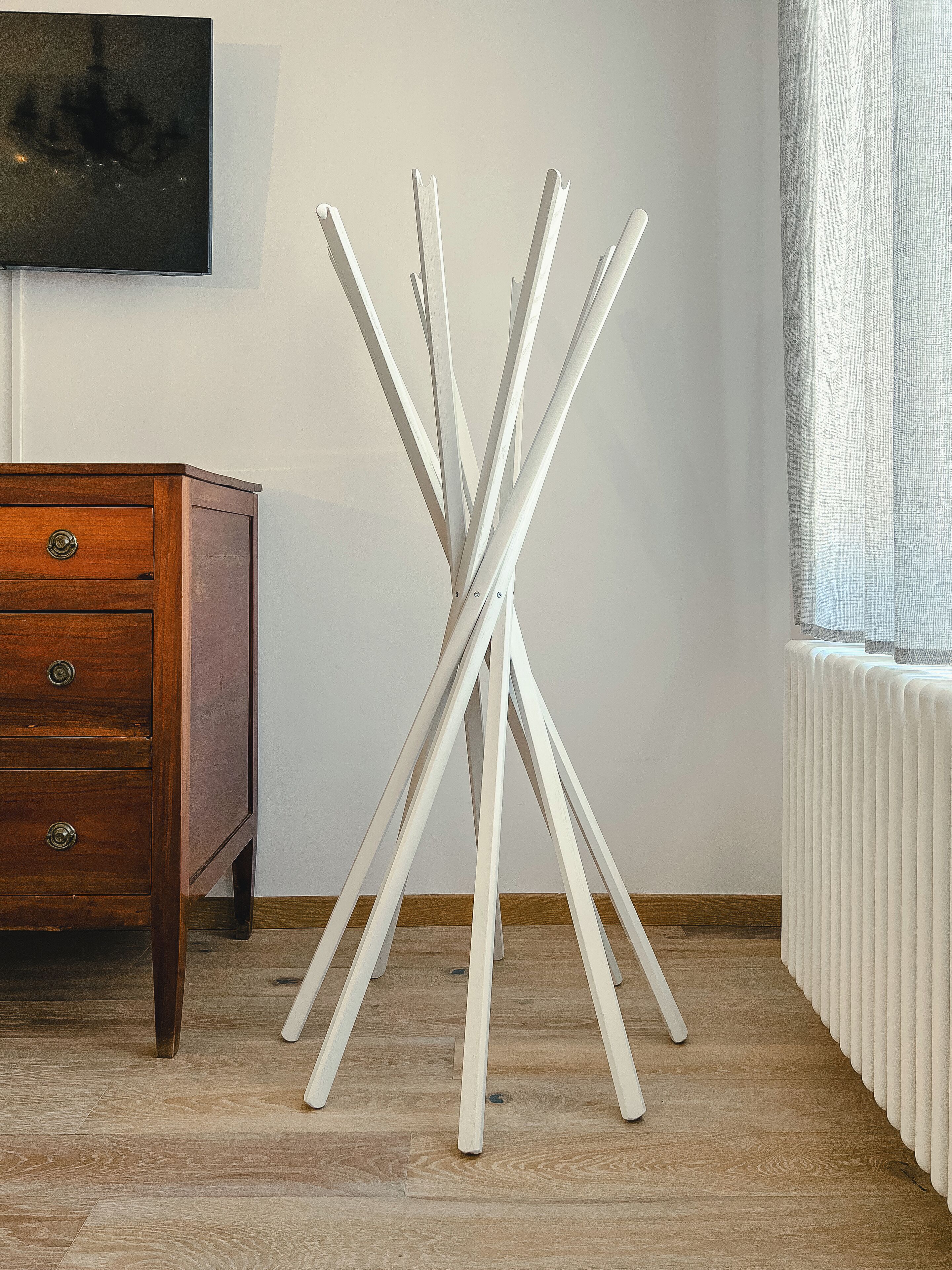 A room with a wooden dresser, a white radiator, and a white radiator cover.