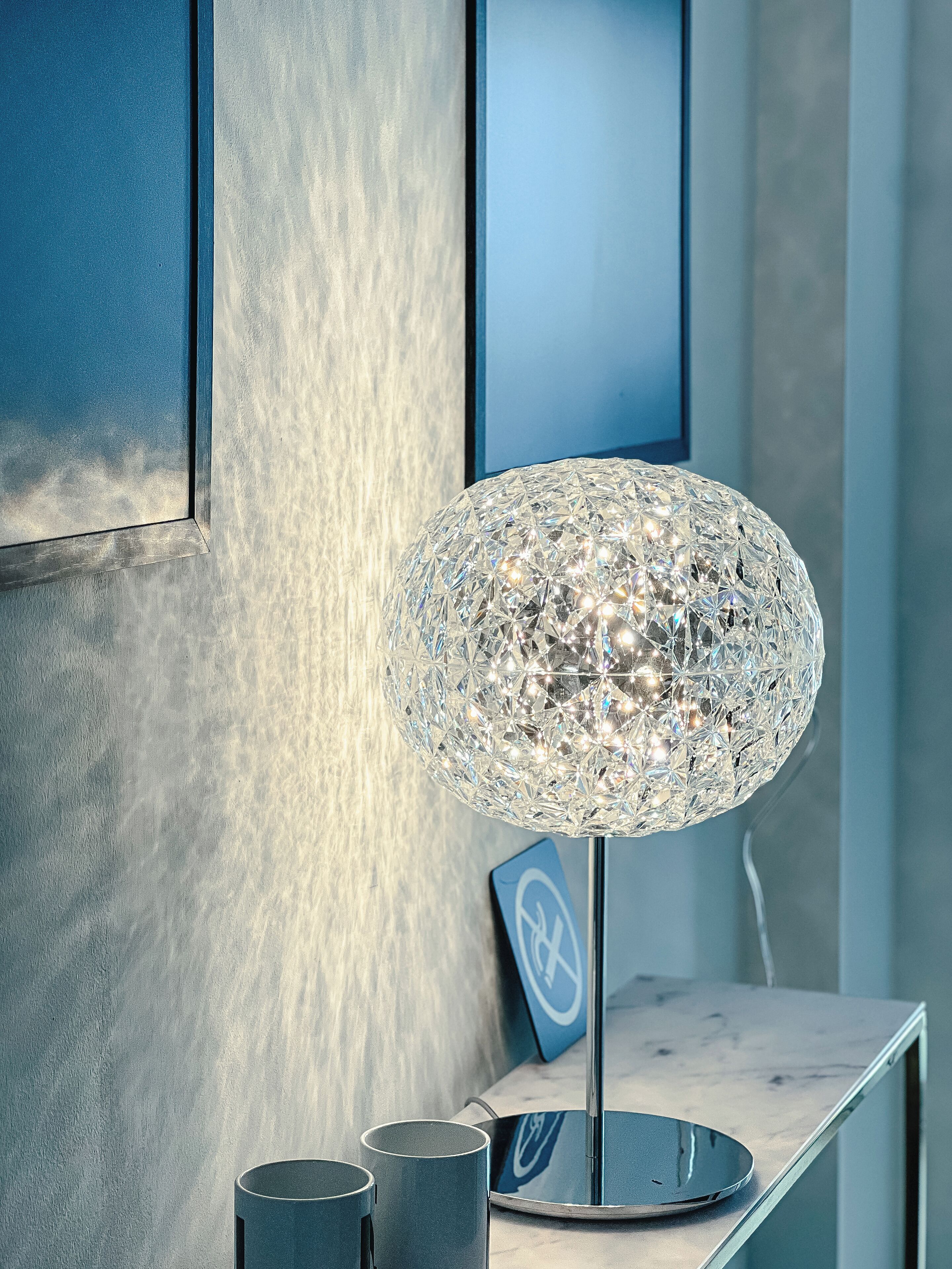 Eine moderne Lampe mit geometrischem Design auf einem Tisch.