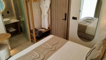 Ein Schlafzimmer mit Bett, Spiegel, Kleiderschrank und Bad.