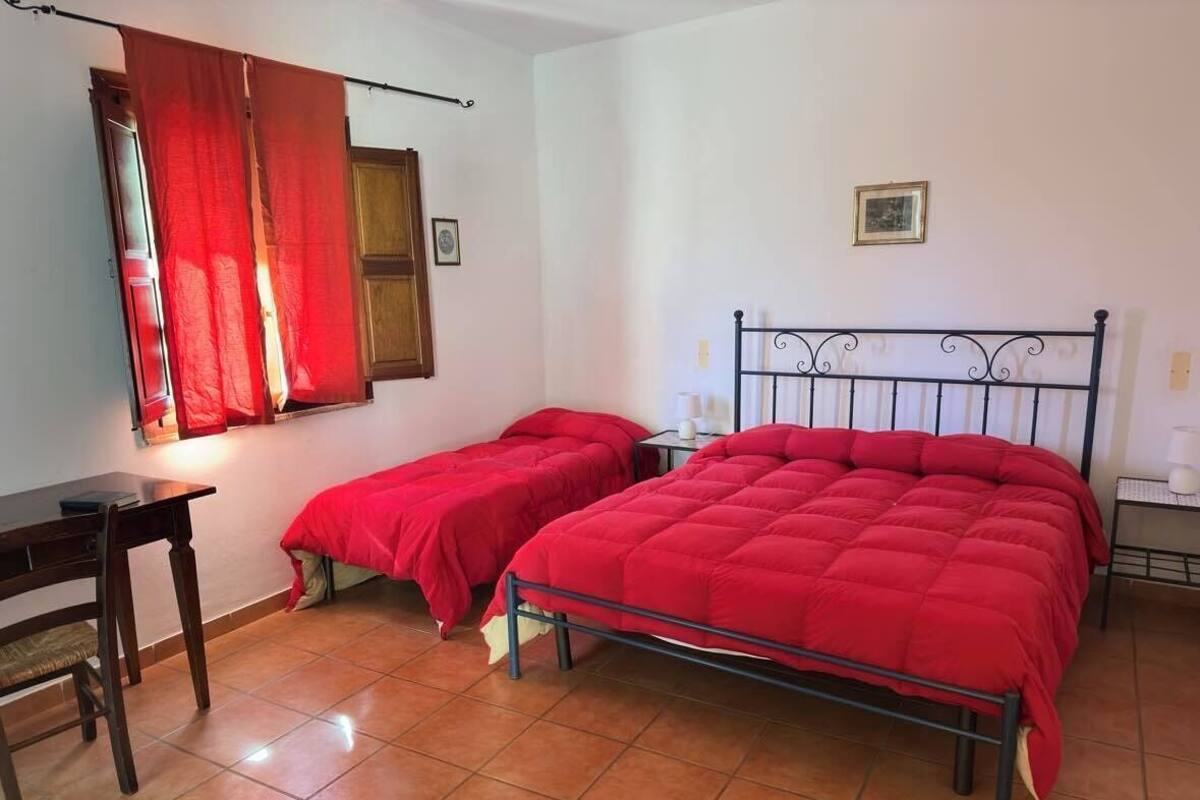 A room with two beds, a desk, and a chair.