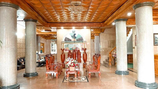 Aulassa on marmoripylväitä, puinen katto ja koristeellisia huonekaluja.
