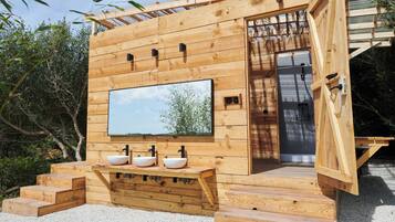 Design huisje, uitzicht op tuin | Badkamer | Een douche, een regendouche, een haardroger, handdoeken