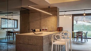 Une cuisine moderne avec un îlot central, des tabourets de bar et une bouteille de vin.