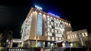 Un hôtel à plusieurs étages, surmonté d’une grande enseigne « TOKYO CLUB » bien visible.