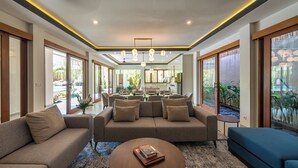 Ein modernes Wohnzimmer mit Sofa, Couchtisch und Essbereich.