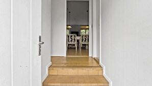 Una escalera que conduce a un comedor con una mesa y sillas.