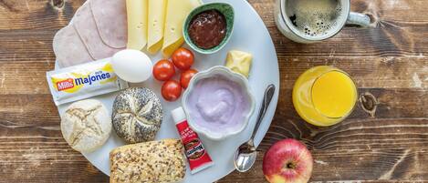 A breakfast plate with ham, cheese, eggs, bread, tomatoes, and a cup of coffee.