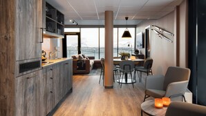 Une cuisine moderne avec des meubles en bois, un coin repas comprenant un canapé et des chaises, et une grande fenêtre offrant une belle vue.