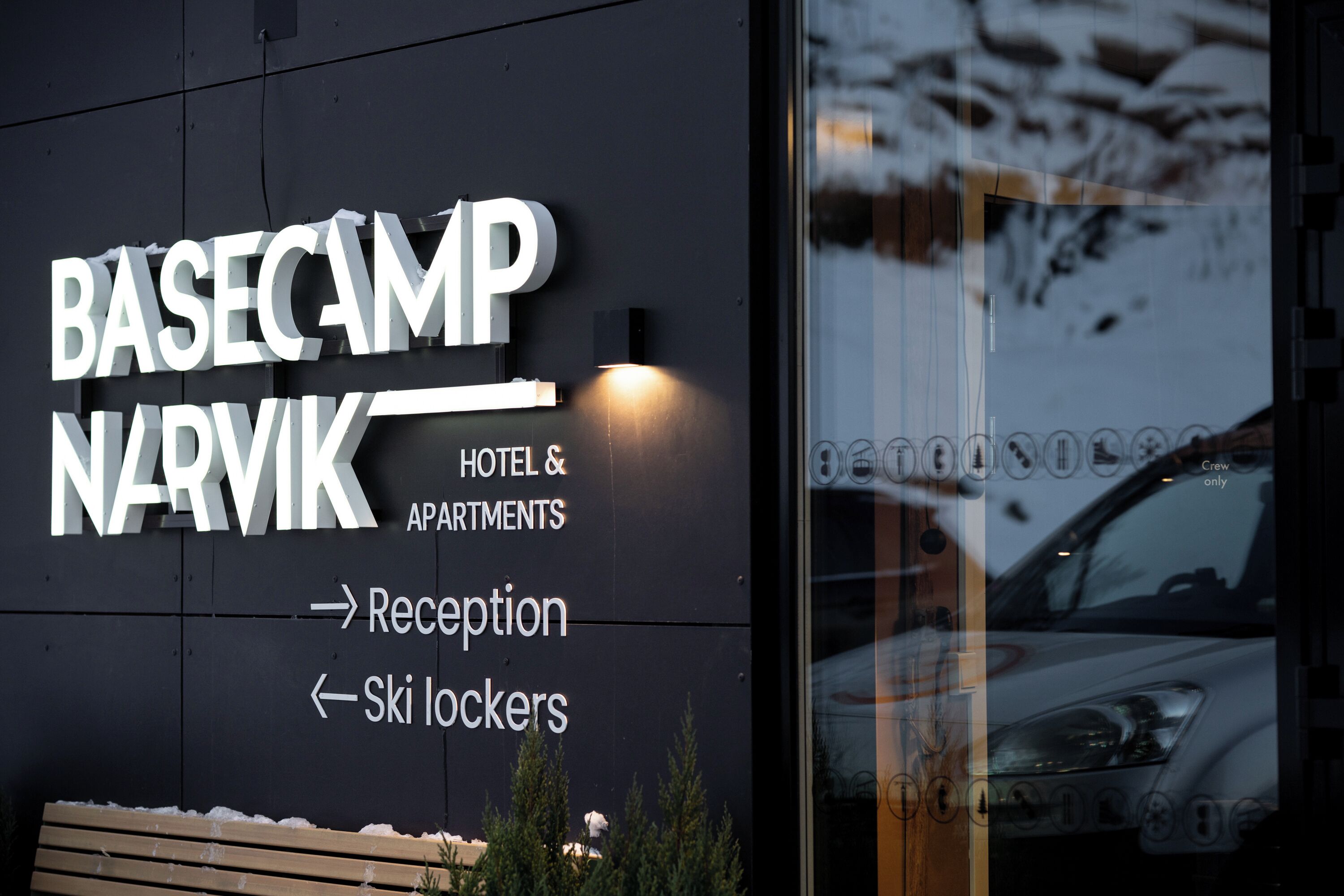 A hotel sign with directional arrows to reception and ski lockers.
