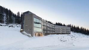 Un hôtel moderne au design original et aux lignes angulaires, situé dans une région montagneuse enneigée.
