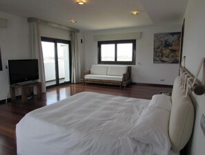 Enjoy a restful stay in this stylish room with a large bed, flat-screen TV, and sliding glass door leading to a scenic outdoor view.