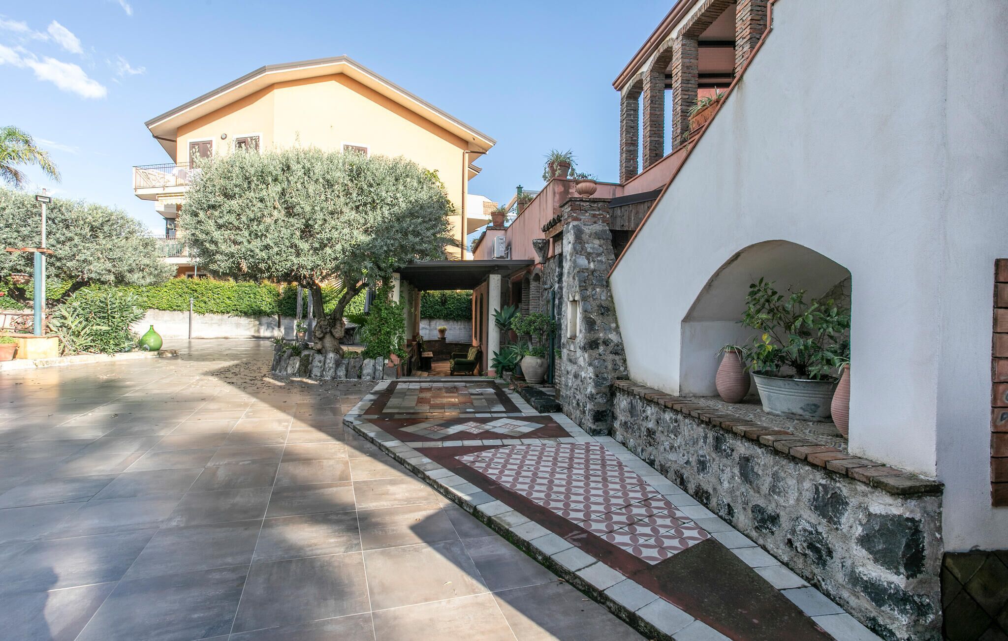 Un patio con un camino empedrado que lleva a un edificio con balcón.