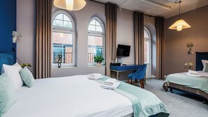 Una habitación de hotel con una cama grande, un escritorio y un televisor.
