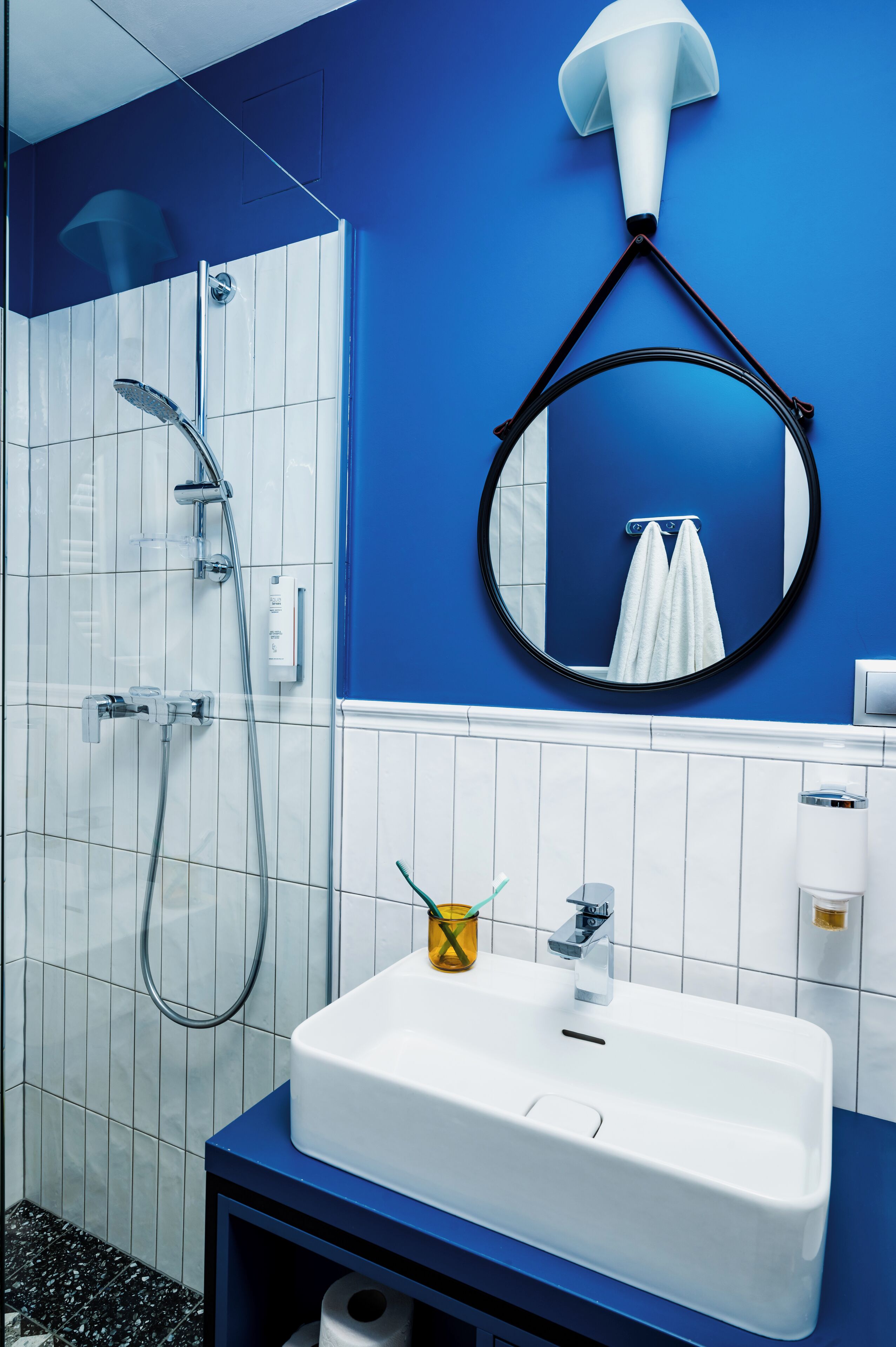 A bathroom with a white sink, a mirror, and a shower.