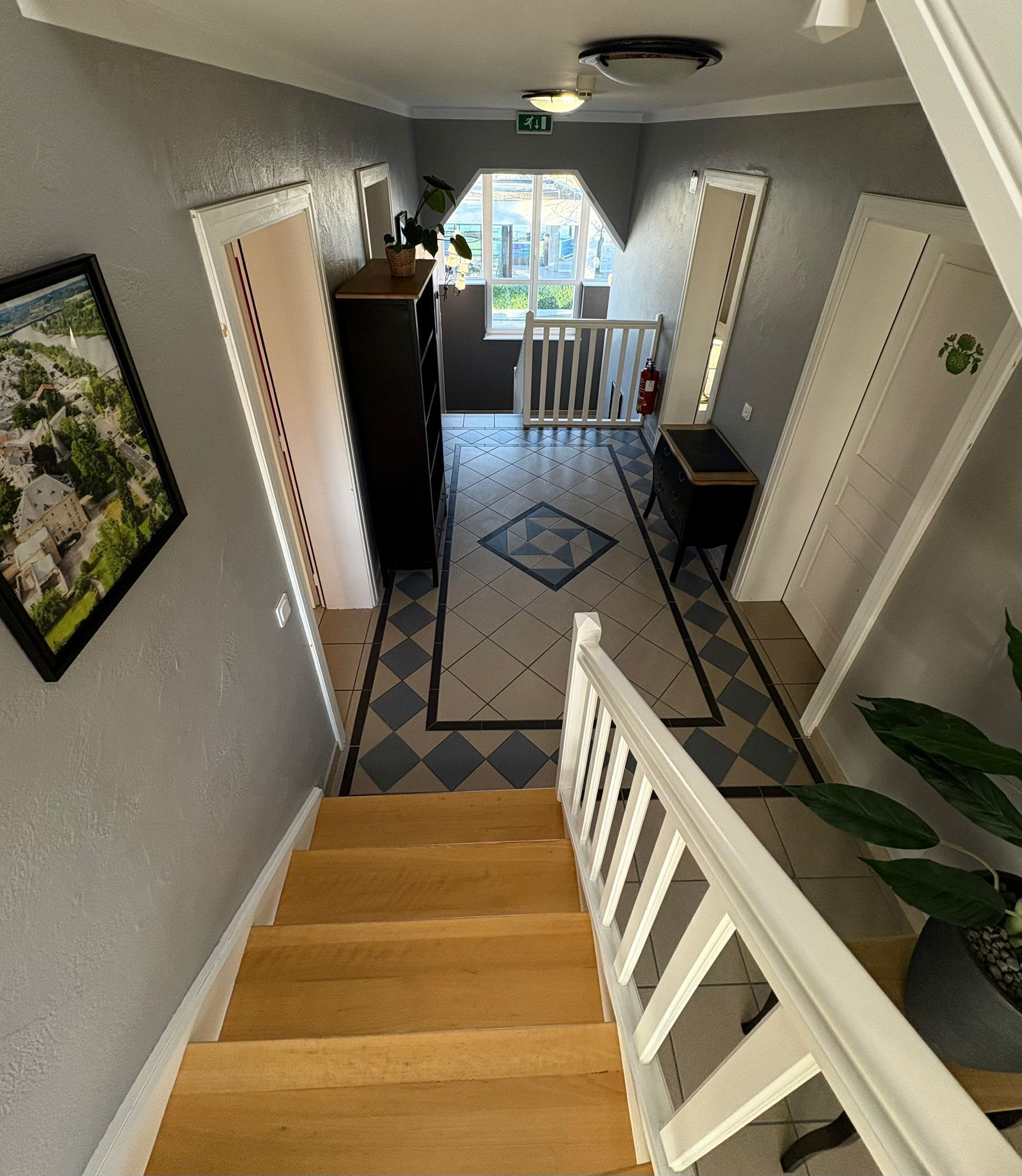 Una escalera conduce a una plataforma desde donde se ve un balcón y una puerta.