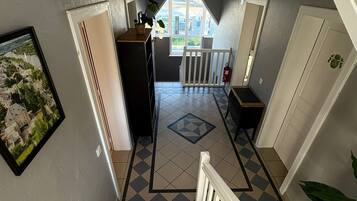 Una escalera conduce a una plataforma desde donde se ve un balcón y una puerta.