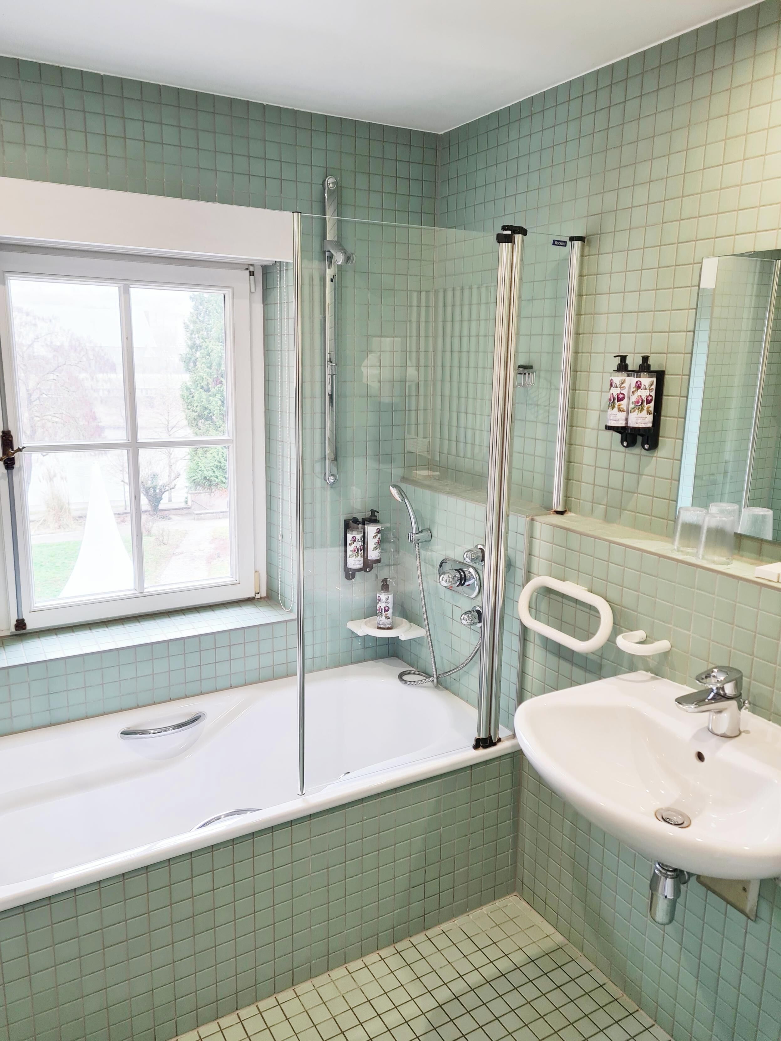 Un baño con bañera, lavamanos y ventana.