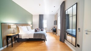 Una camera da letto moderna con un letto, un comodino e un ampio specchio.