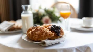 A breakfast setting with croissants and orange juice on a table.