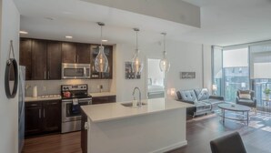 A modern kitchen with dark wood cabinets, stainless steel appliances, and pendant lighting. - 3380 Peachtree Rd NE Atlanta, GA 30326, USA (Atlanta)