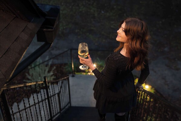 A person standing on a balcony holding a glass of wine. - Rhythm at The Key | 1mi to UF & DT • Full Kitchen (Gainesville)