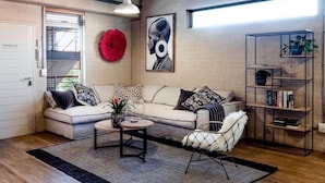 Una sala de estar con sofá, sillón, mesa de centro y estantería.